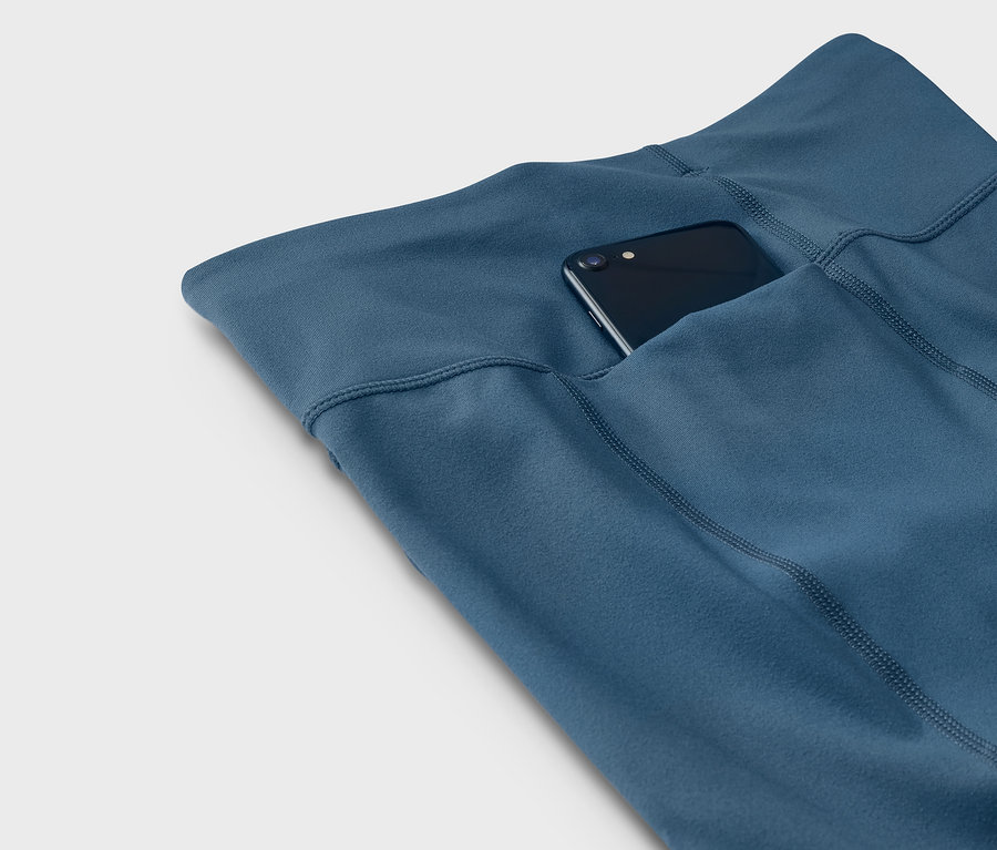 Blaue Leggings mit einem Telefon in der Tasche.