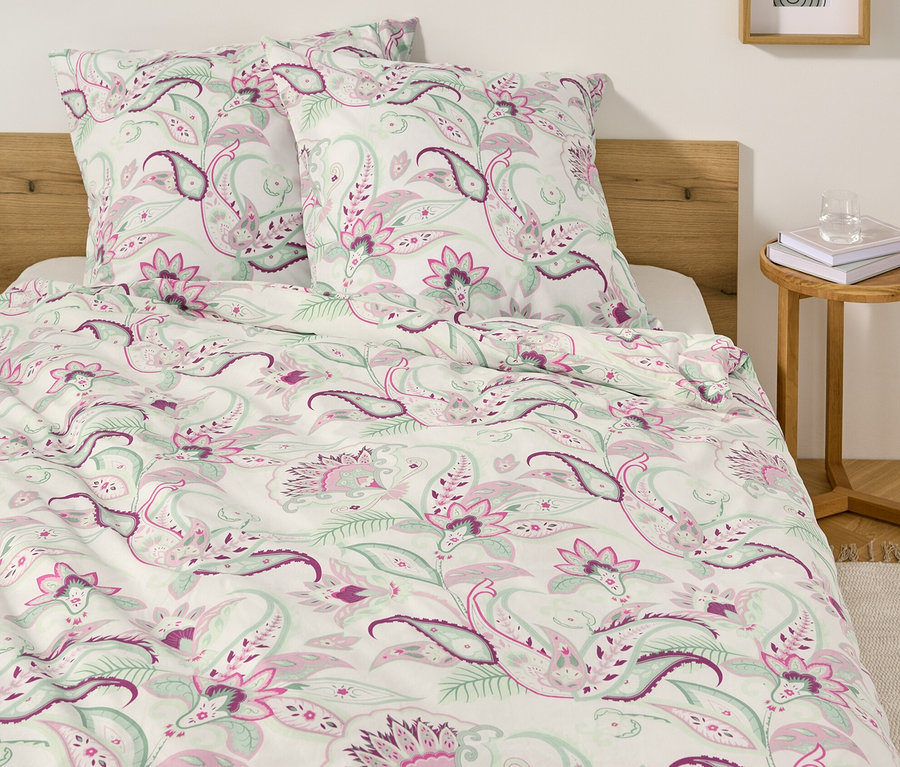 Bett mit weißer Renforcé-Bettwäsche mit Paisley-Muster und zwei Kissen.