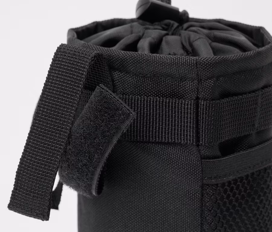 Detailaufnahme einer schwarzen Fahrrad-Snacktasche mit Kordelzug und Klettverschlussriemen.