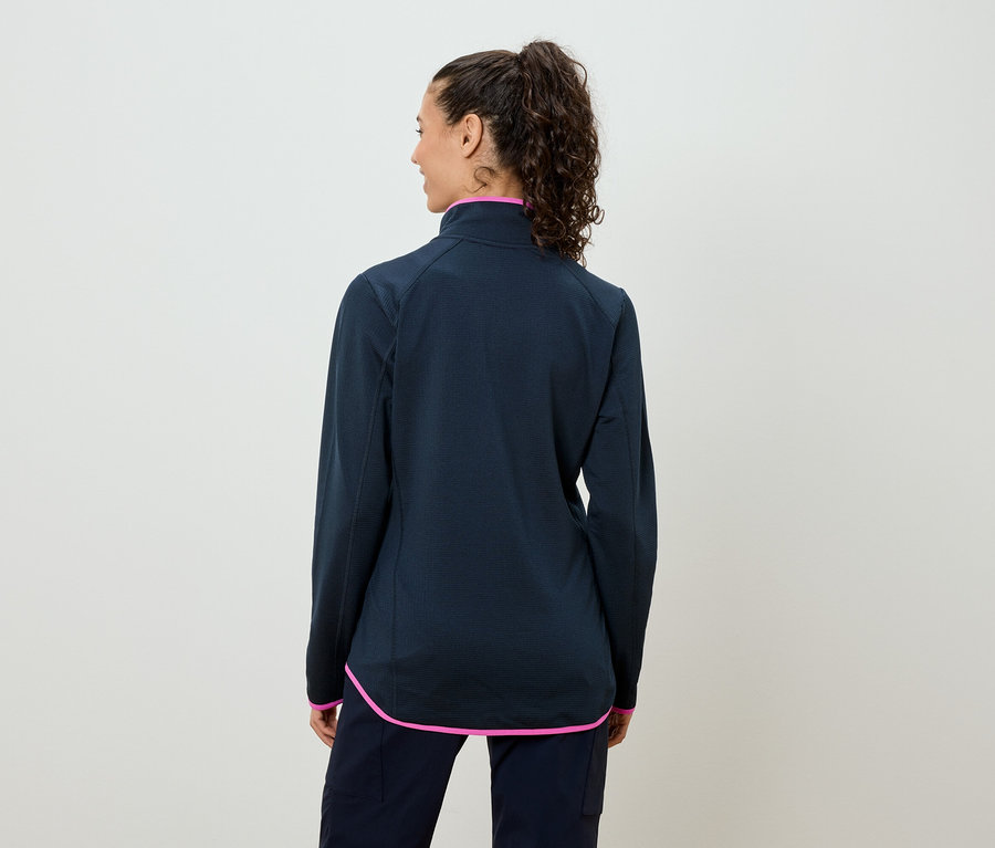 Rückansicht einer Frau mit lockigem Haar, die eine dunkelblaue Jacke mit pinkfarbenen Akzenten trägt.