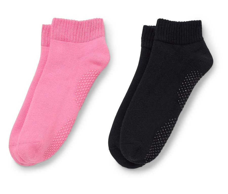 Zwei Paar Socken, ein Paar pink, ein Paar schwarz, liegen nebeneinander.