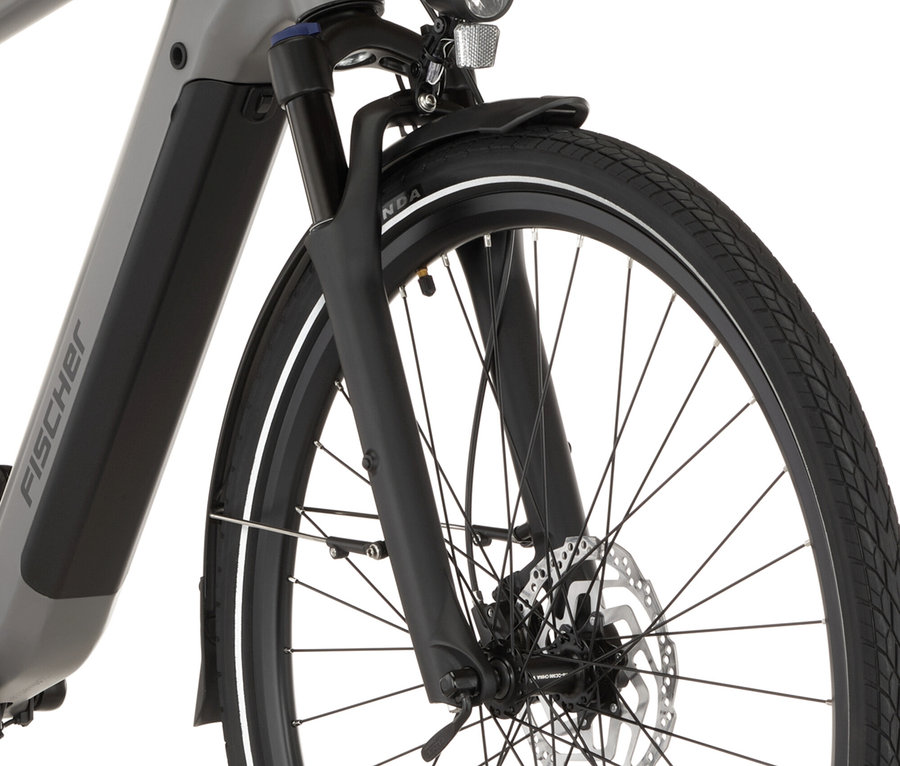 Nahaufnahme des FISCHER Trekking-E-Bike VIATOR MOVE mit Diamant-Rahmen, das Vorderrad, die Federgabel und den Scheinwerfer zeigt.