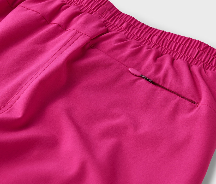 Nahaufnahme einer pinkfarbenen Hose mit elastischem Bund und Reißverschlusstasche.