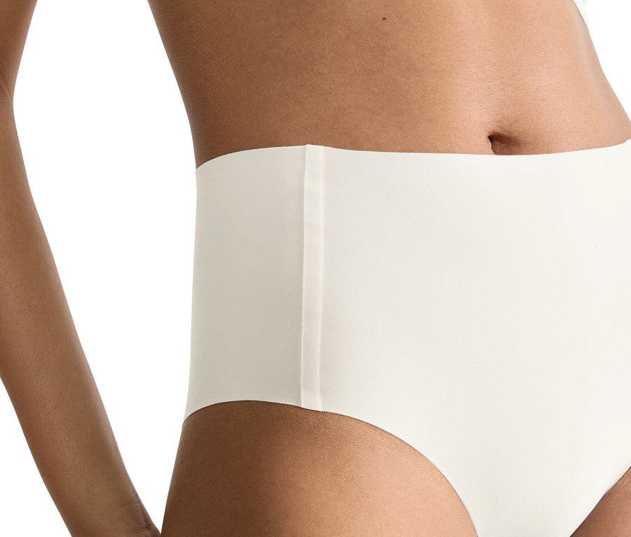 Frau trägt eine seidenweiße sloggi ZERO Feel 2.0 High Waist Panty und ein passendes Bustier, ihr linker Arm ist sichtbar.