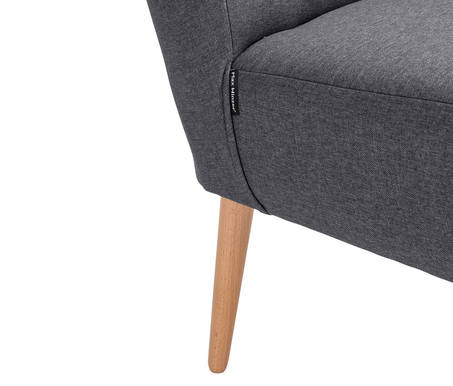 Detailaufnahme eines grauen Sessels mit Holzbein.