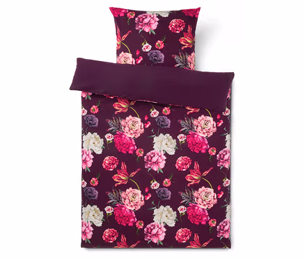 Dunkelviolette Bettwäschegarnitur mit lebhaftem Blumenmuster aus rosa, fuchsiafarbenen und weißen Pfingstrosen.