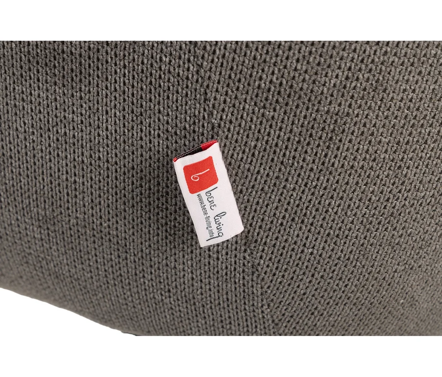Nahaufnahme eines dunkelgrauen, gestrickten Stoffs des deVries Diningsessels Ginosa mit einem weißen Etikett, das „loene living“ und „www.loene-living.info“ zeigt.