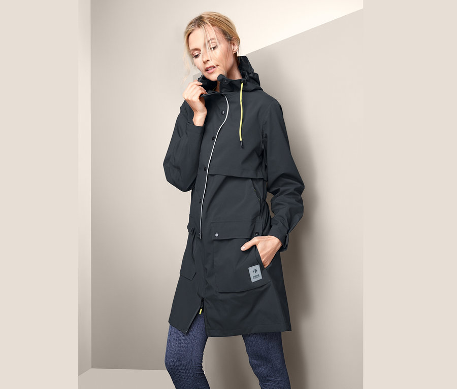 Frau richtet Funktions-Regenparka.