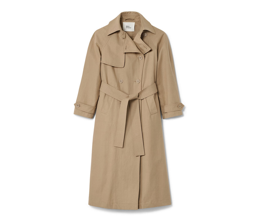 Ein beiger NAH/STUDIO Trenchcoat aus recycelter Baumwolle mit Gürtel.