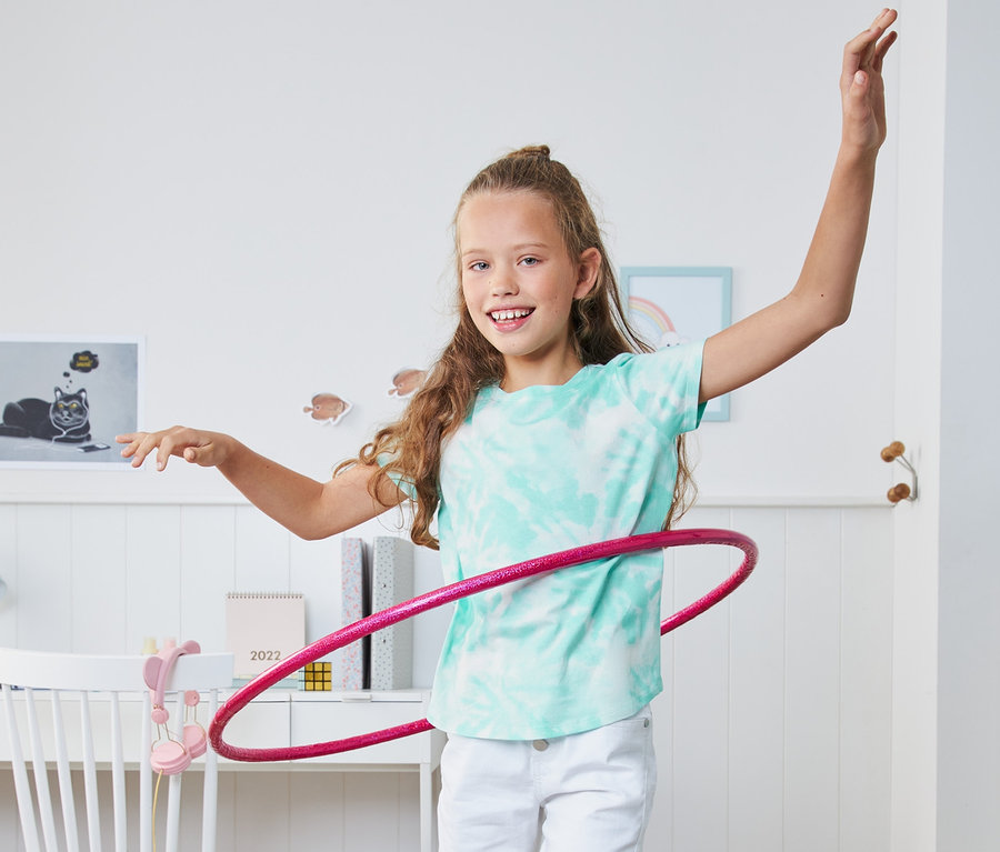 Mädchen macht Hula-Hoop im 2 T-Shirts.