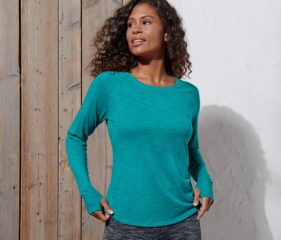 Frau posiert im Langarm-Sportshirt.