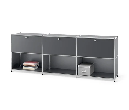 Graues Sideboard Metall »CN3« mit 3 versetzbaren Klappenfächern. In den unteren Fächern liegen Bücher und eine graue Kiste.