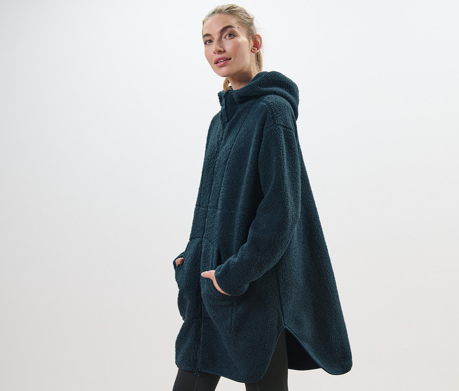 Frau posiert in einem oversized Teddy-Mantel.
