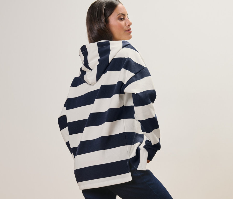 Frau posiert in einem gestreiften Hoodie.