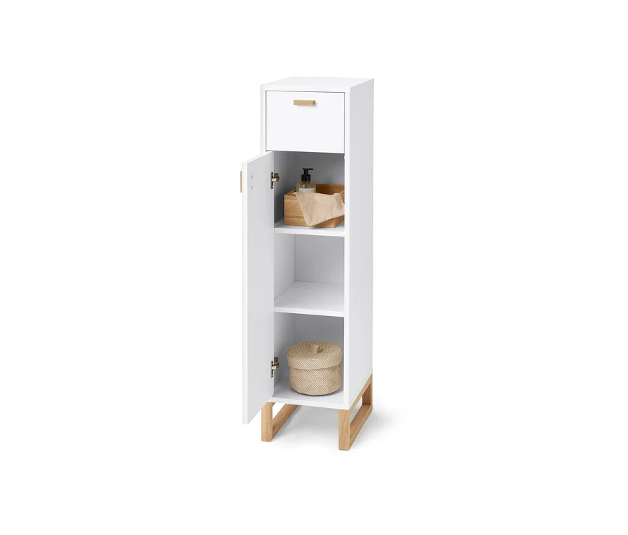 Schmaler Bad-Beistellschrank mit Schublade und Tür. Innen sind Seife, Handtuch und ein Weidenkorb.