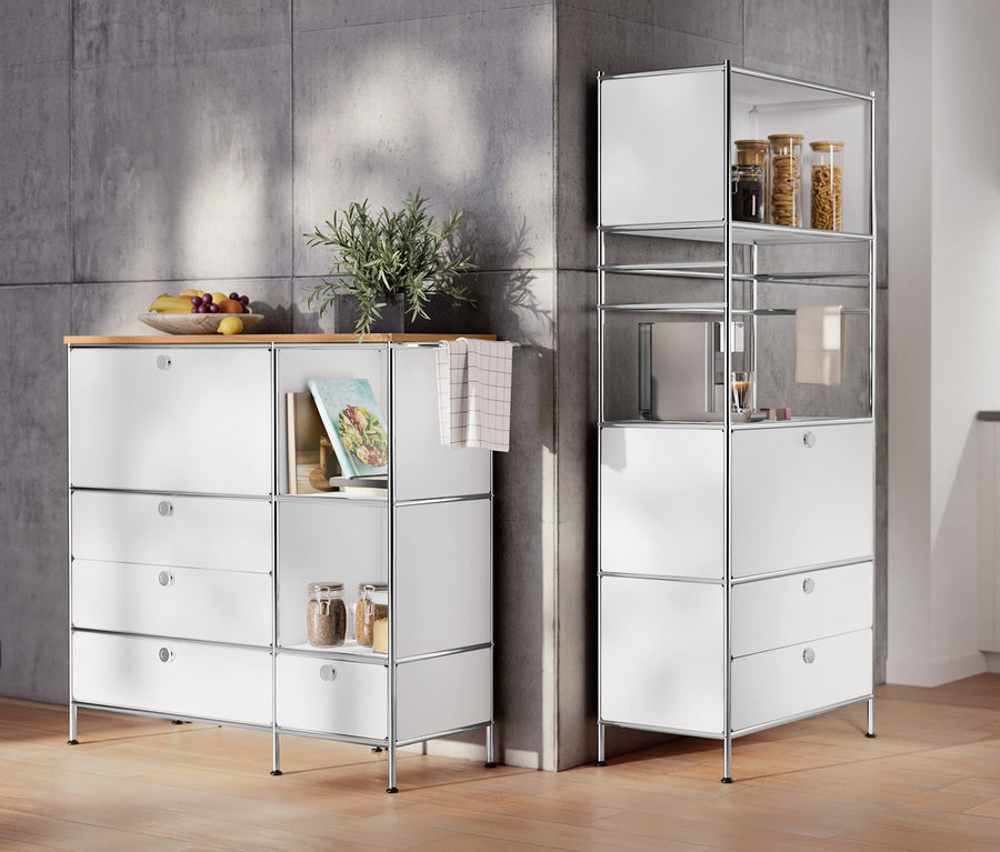 Im Raum stehen ein Sideboard Metall »CN3« mit Holzplatte, 1 Klappenfach und 4 Schubladen, weiß und ein Regal Metall »CN3« mit 1 Klappenfach und 2 Schubladen.