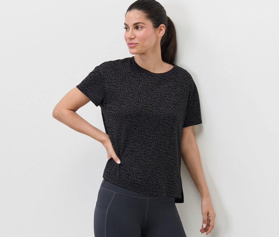 Frau posiert in anthrazitfarbenem Sportshirt.