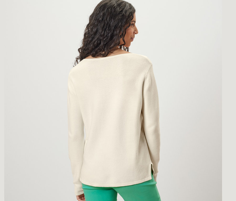 Frau von hinten trägt einen cremeweißen Strickpullover.