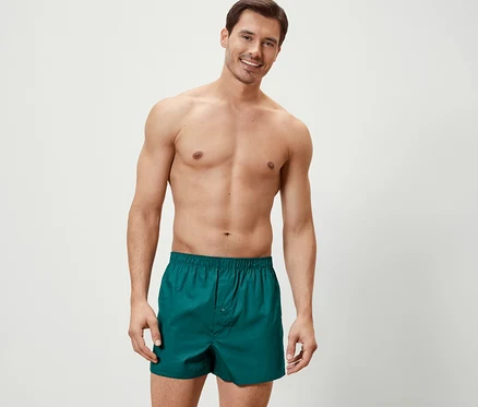 Mann posiert in grünen 2 Web-Boxershorts.
