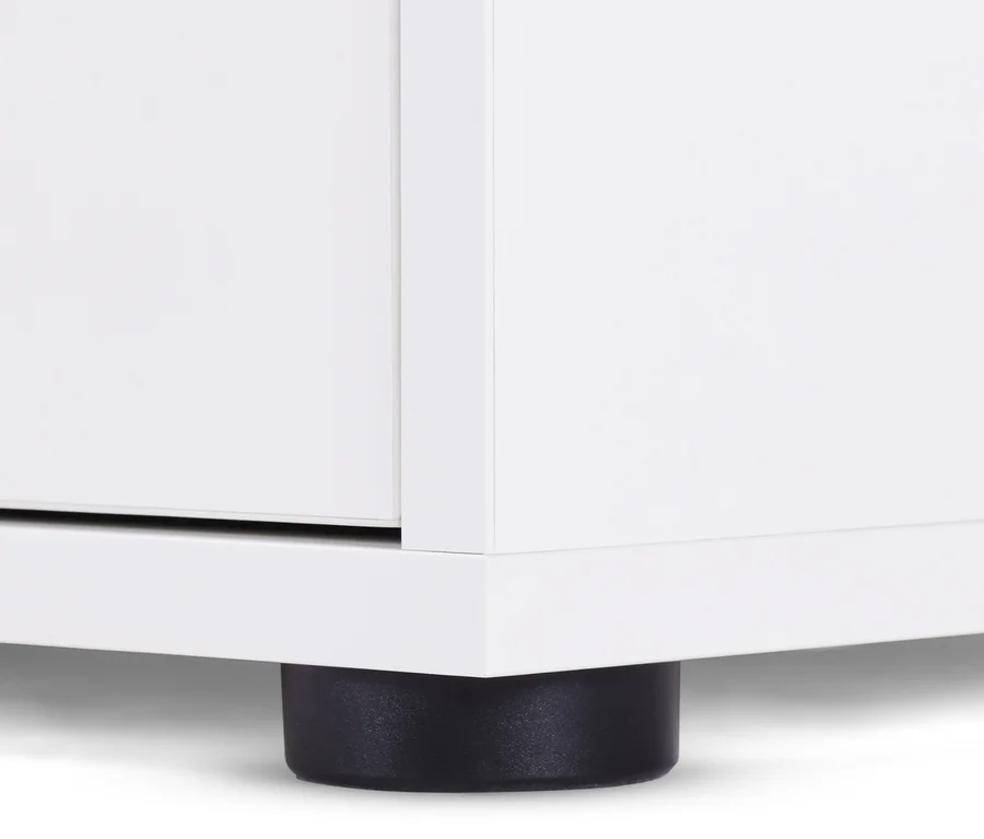 Detailaufnahme eines weißen Sideboards mit Schubladen und Tür, stehend auf einem schwarzen Fuß.