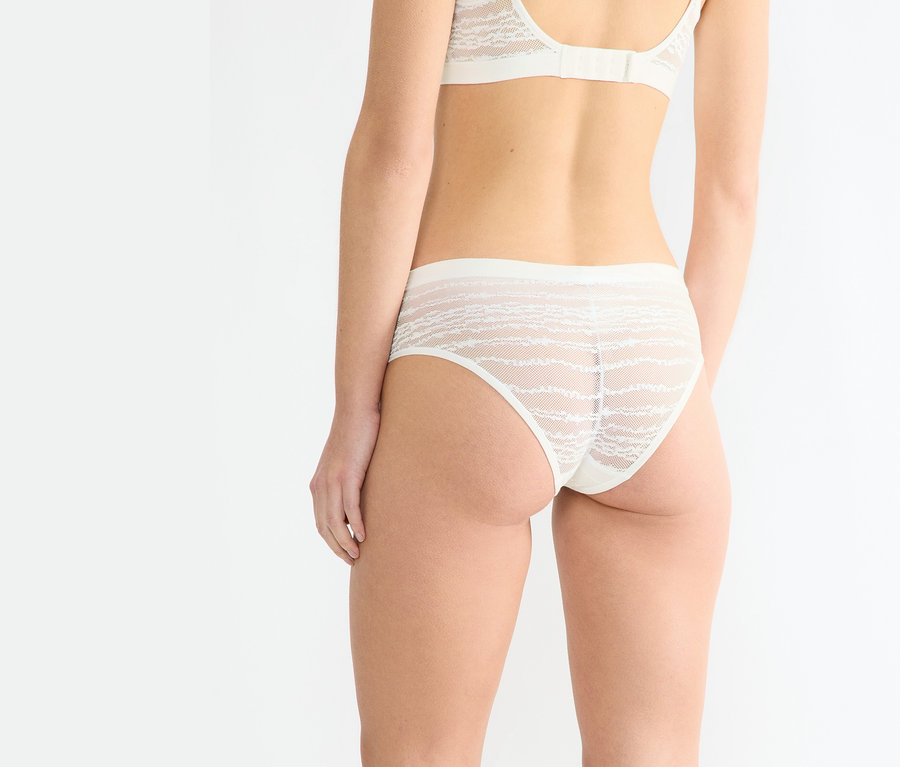 Frau von hinten in sloggi Free Evolve Hipster Lace in Seidenweiß und passendem BH.