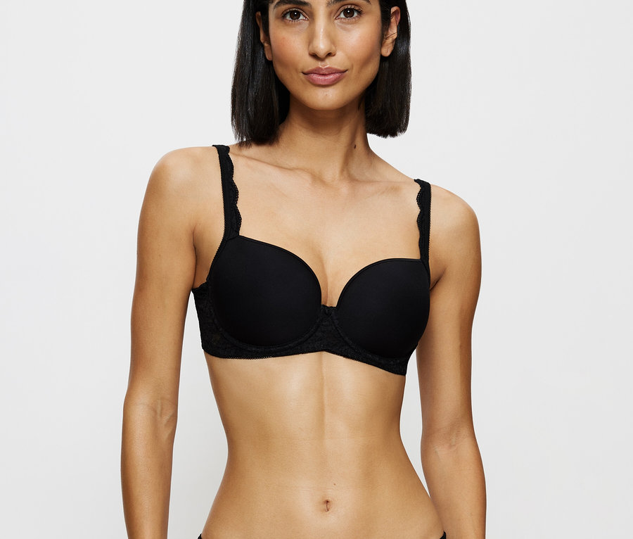 Frau trägt schwarzen Spitzen-BH und Höschen.