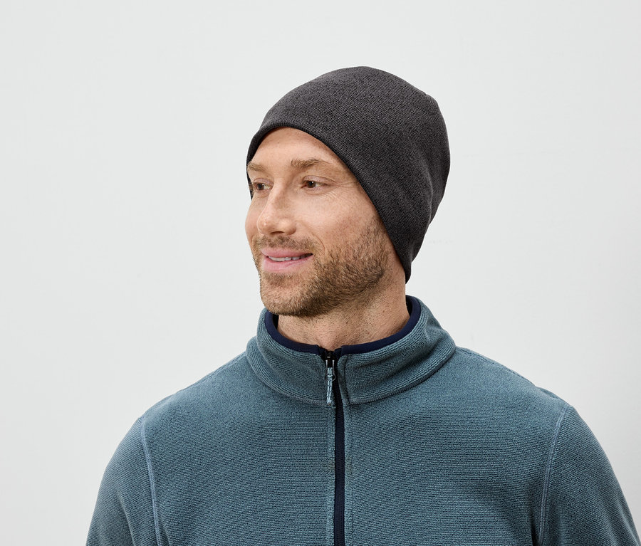 Mann mit Bart, grauer Mütze und blauem Fleecepullover blickt nach rechts.