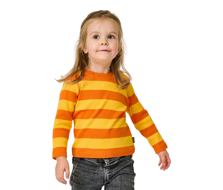Lächelndes Mädchen in orange-gelb gestreiftem Langarmshirt und Jeanshose.