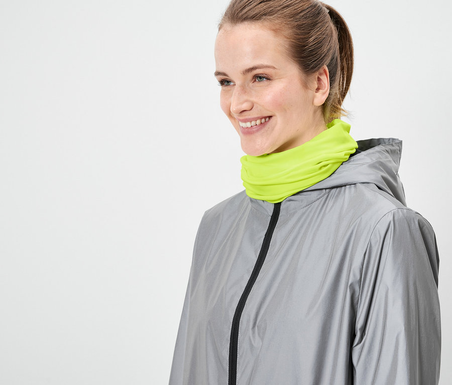 Frau trägt graue Jacke und neon-grünen Schal.