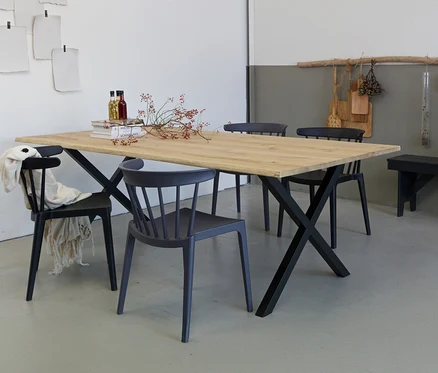Holzesstisch mit schwarzem Metallgestell, umgeben von vier Stühlen in verschiedenen Grautönen.