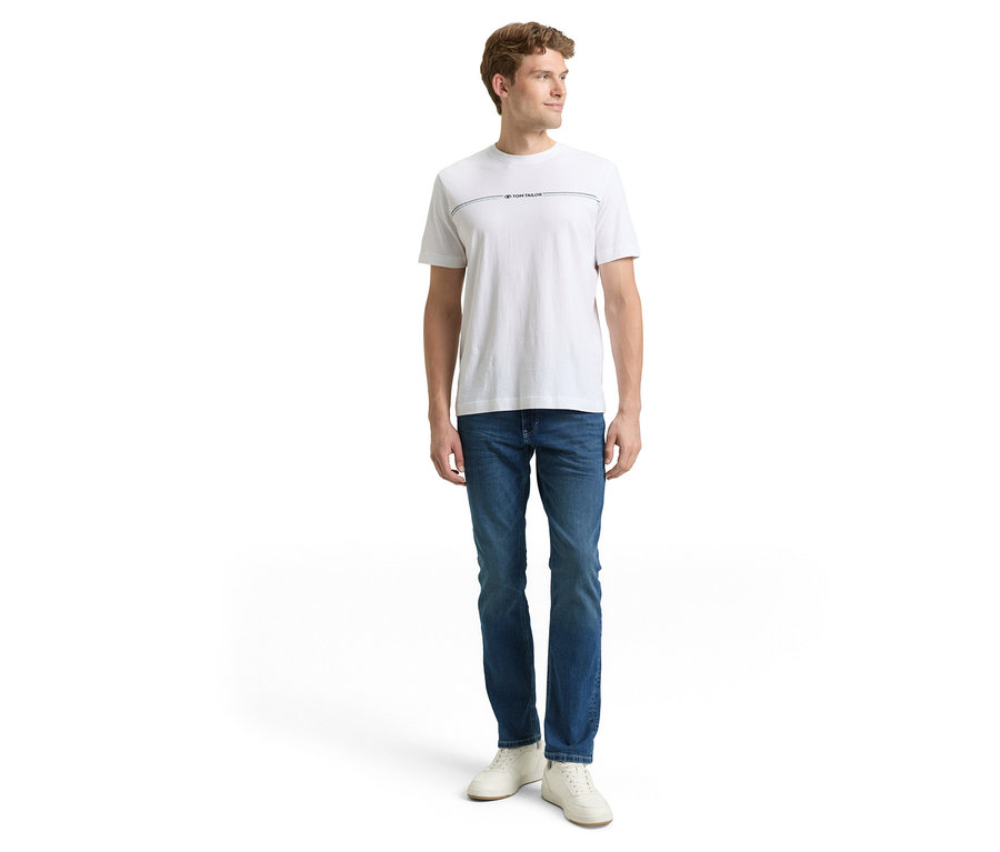 Mann in Jeans und T-Shirt. Er trägt eine Tom Tailor TT MARVIN STRAIGHT Jeans mit Stretch, Used Mid Stone Blue Denim.