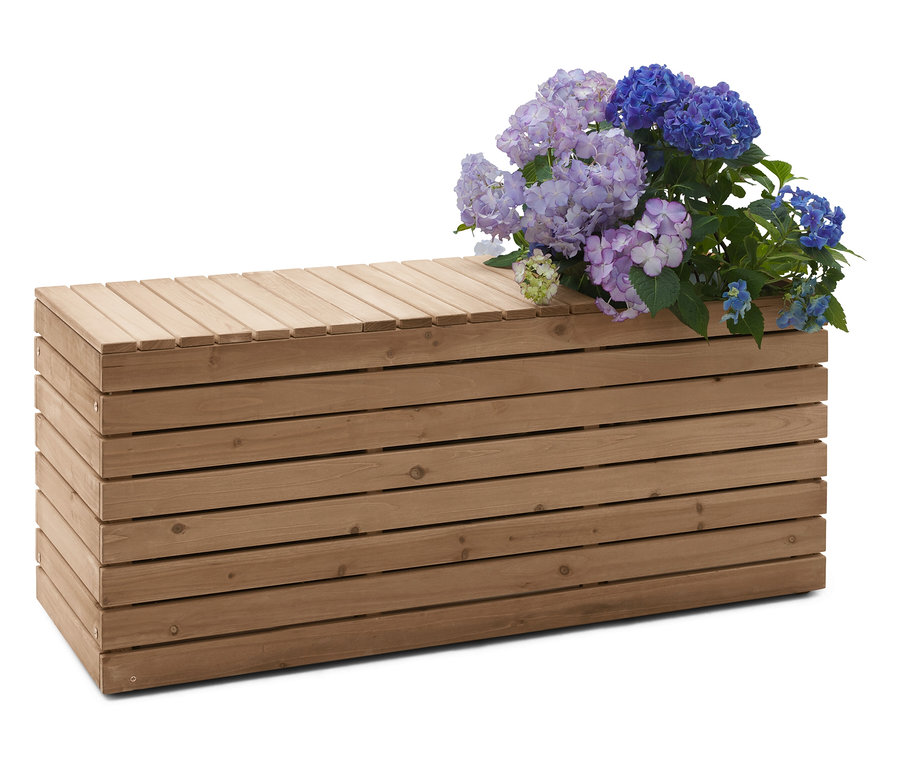 Holzbank mit blauen und lilafarbenen Hortensien.