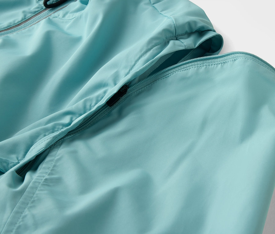 Detailaufnahme einer hellblauen Jacke mit Reißverschluss.
