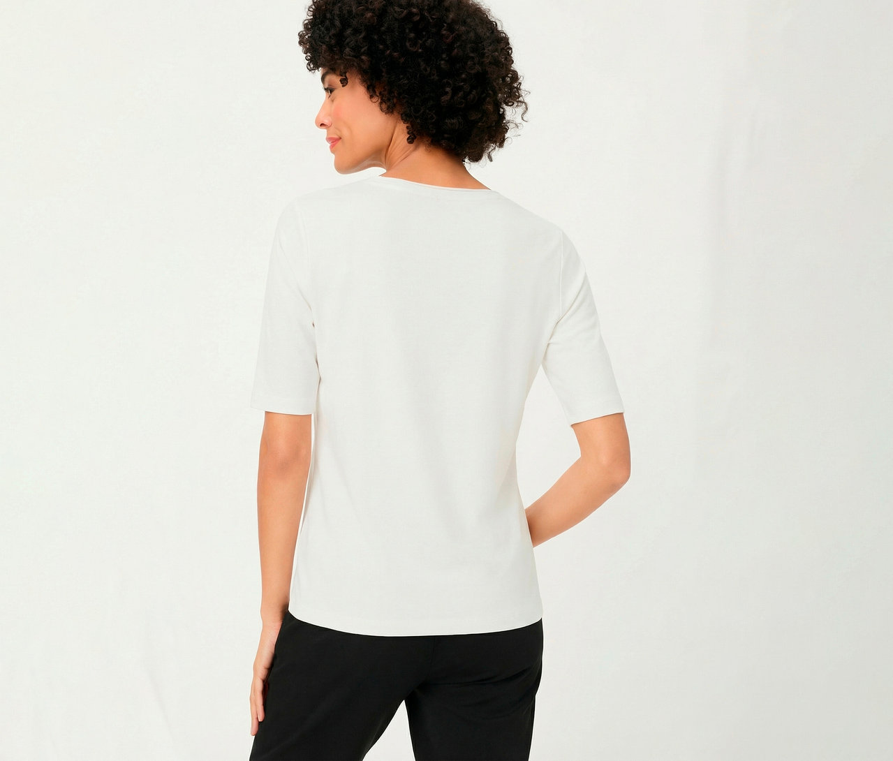 Frau von hinten mit schwarzer Hose und weißem Olsen 3/4-Shirt.