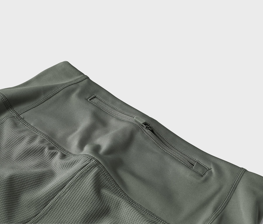 Detailaufnahme einer olivgrünen Hose mit Reissverschlusstasche.