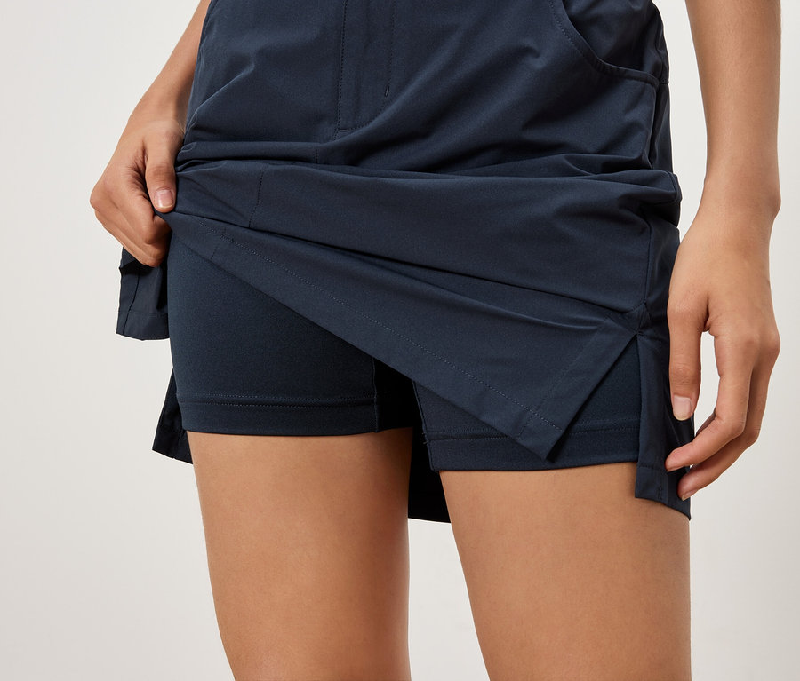 Nahaufnahme einer Frau, die einen marineblauen Rock mit Shorts darunter hochhebt.