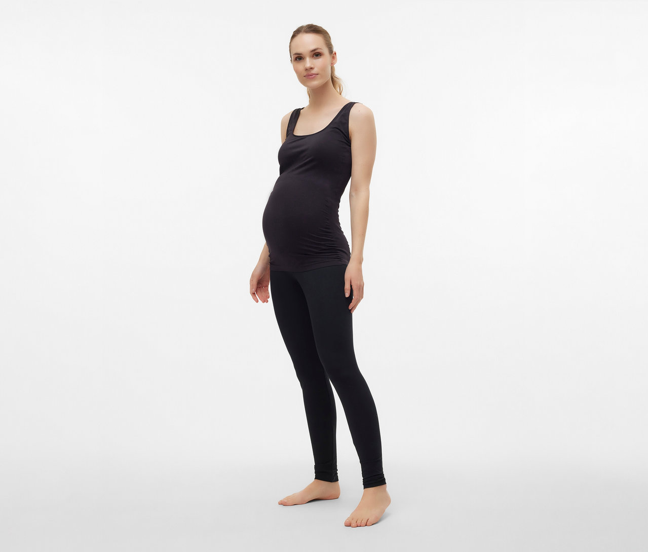Schwangere trägt ein schwarzes MAMALICIOUS Tanktop »MLHEAL« in Einheitsgröße, kombiniert mit Leggings.