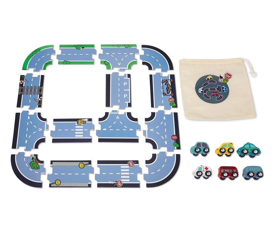 Ein Auto-Spiel-Set mit Spielstraße zum Legen ist auf dem Boden ausgebreitet, daneben liegen ein Stoffbeutel und kleine Autos.