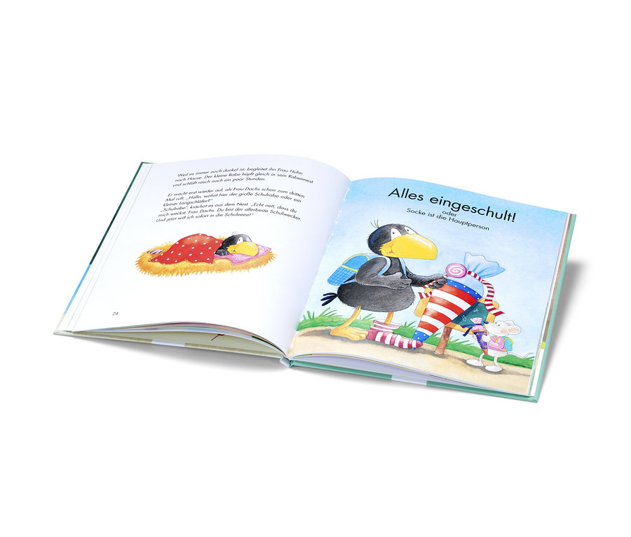 Aufgeschlagenes Buch illustriert einen kleinen Raben mit Schultasche und einer Schultüte.