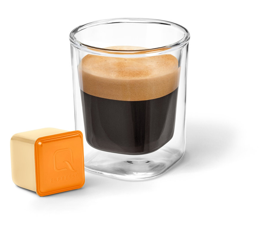 Ein Glas mit Kaffee und eine Kapsel Qbo Flavoured Espresso Caramel.