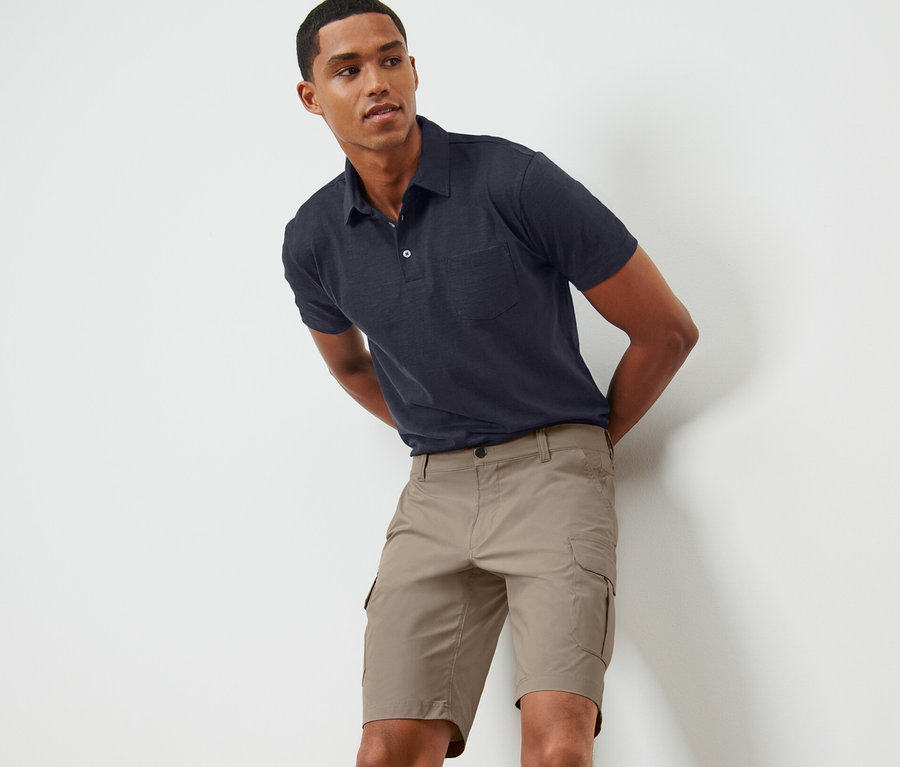 Mann posiert in beigen Funktionsshorts.
