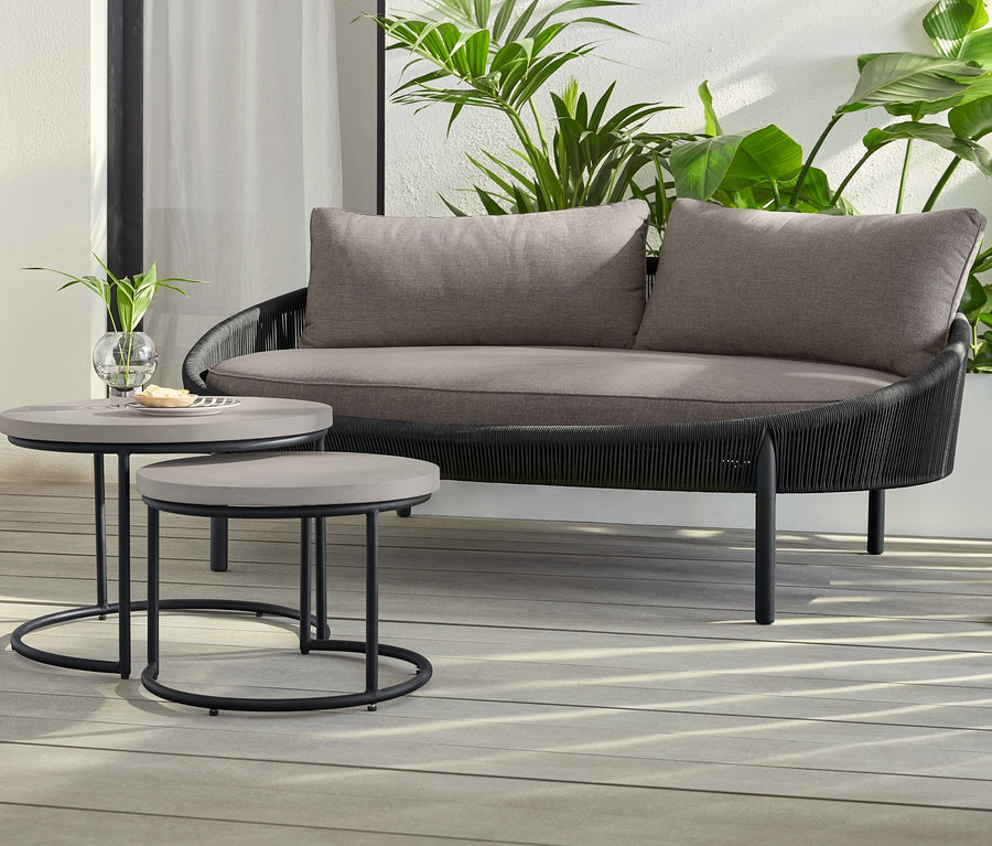 Zwei LED-Akku-Stehleuchten stehen neben 2 Couchtischen mit Beton-Tischplatte und Daybed »Jara« mit Textilgeflecht.