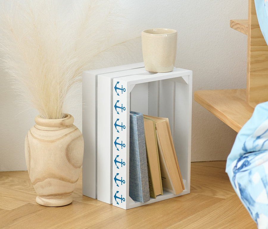 Dekorative Holzkiste mit Büchern, Vase mit Pampasgras und Tasse.