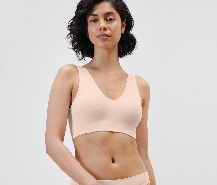 Frau posiert in einem nahtlosen Bustier in Creme.