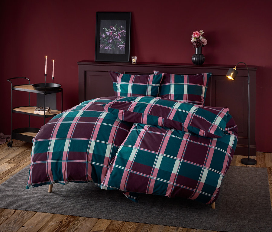 Ein kariertes Bettwäsche-Set auf einem Bett in einem Schlafzimmer.