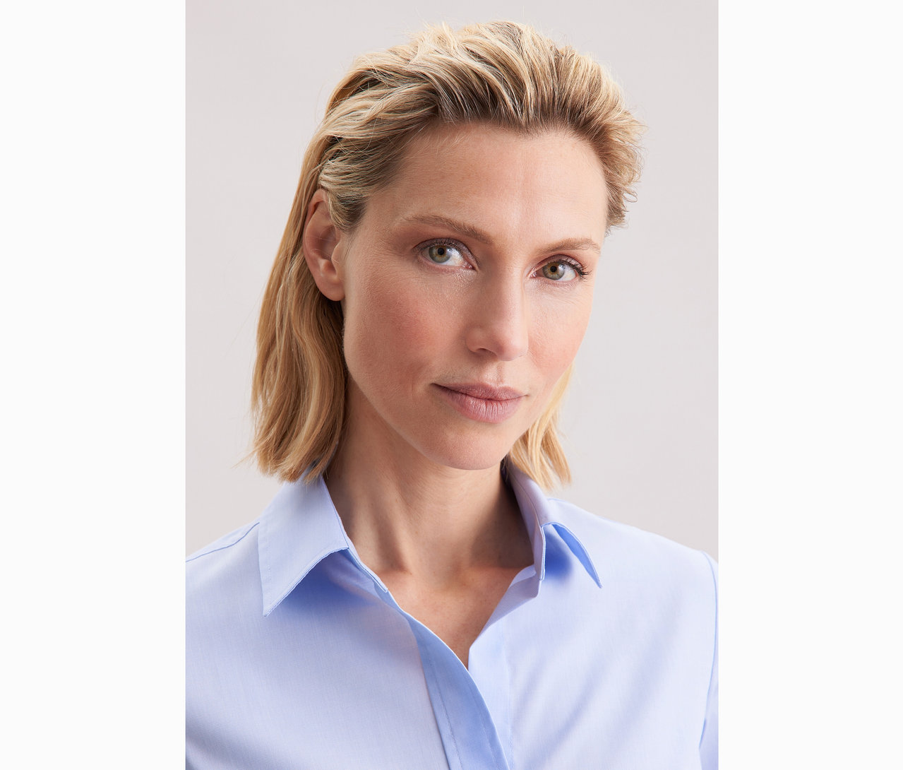 Frau trägt hellblaue Seidensticker Bluse Slim Fit non iron.