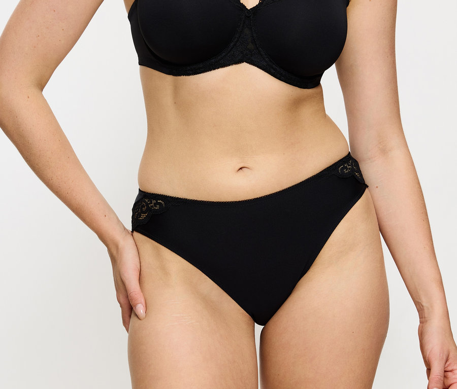 Frau trägt schwarzen BH und Triumph Amourette Tai Slip, black.