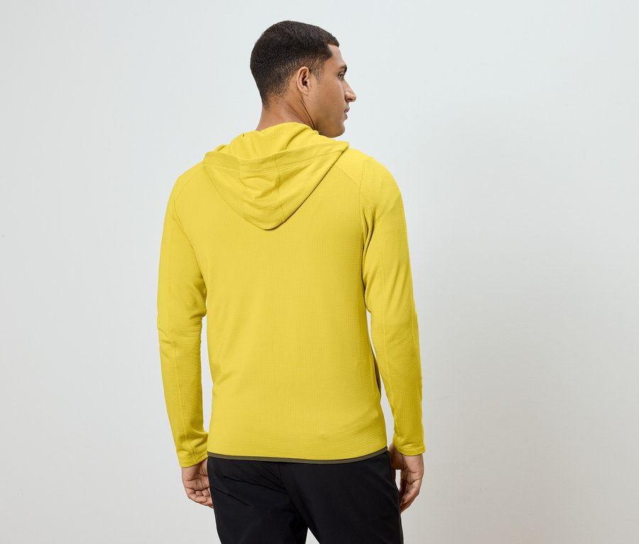 Mann von hinten in gelbem Kapuzenpullover und schwarzer Hose.