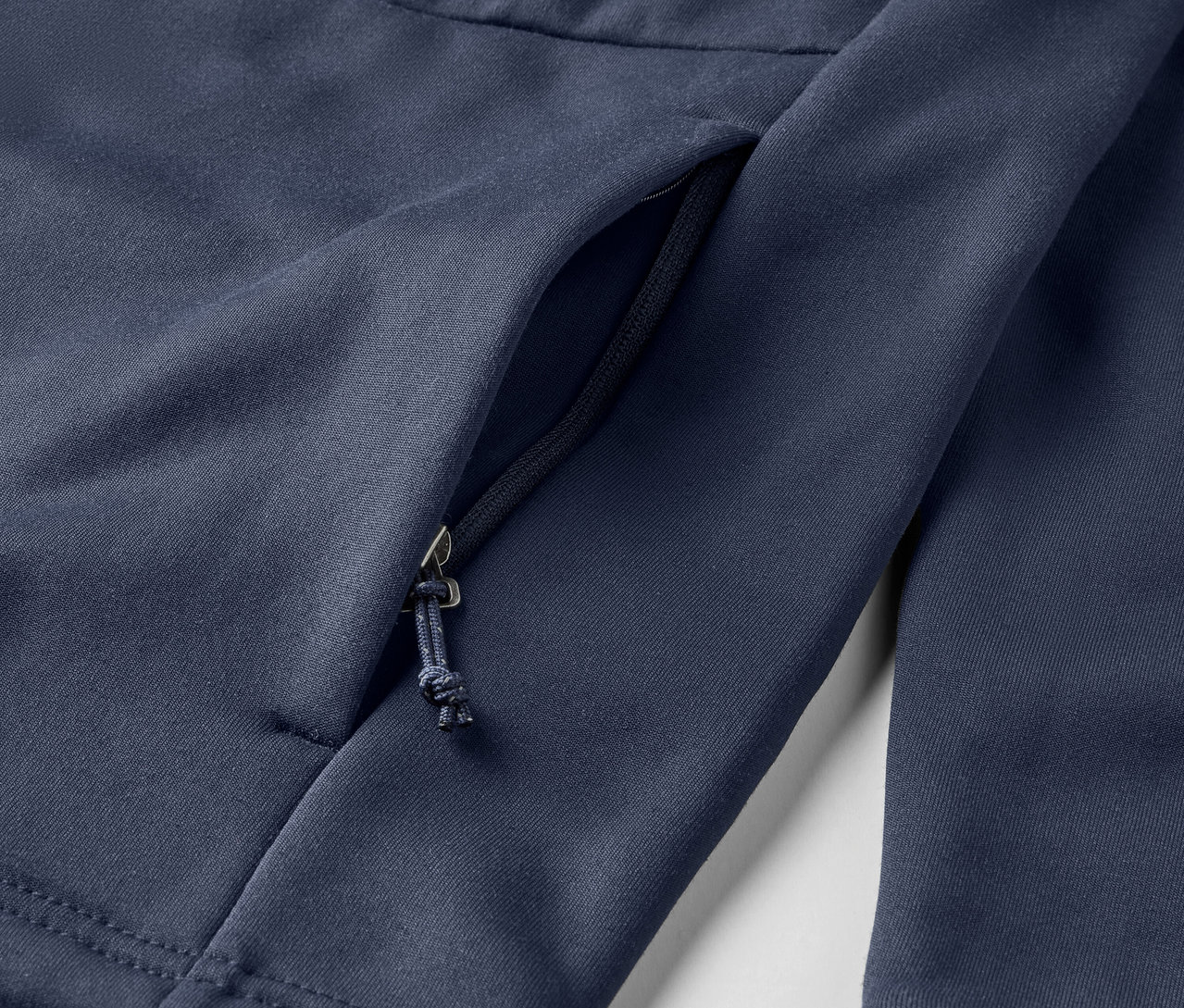 Detailaufnahme einer blauen Fleecejacke mit Reissverschlusstasche.