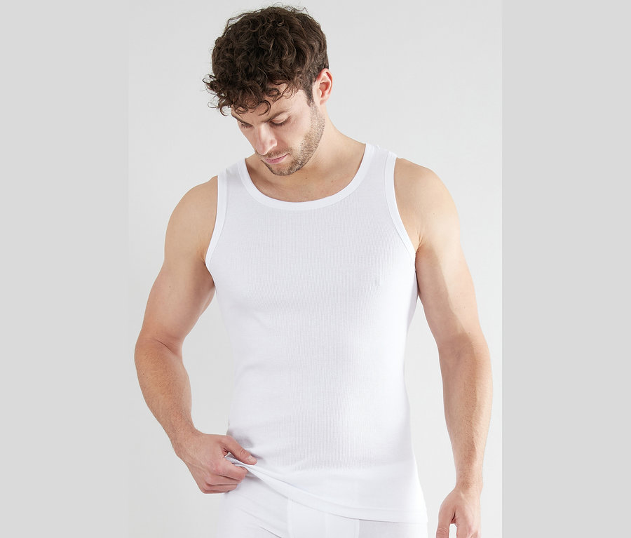 Mann trägt ein weißes Rippenunterhemd und Unterhose.